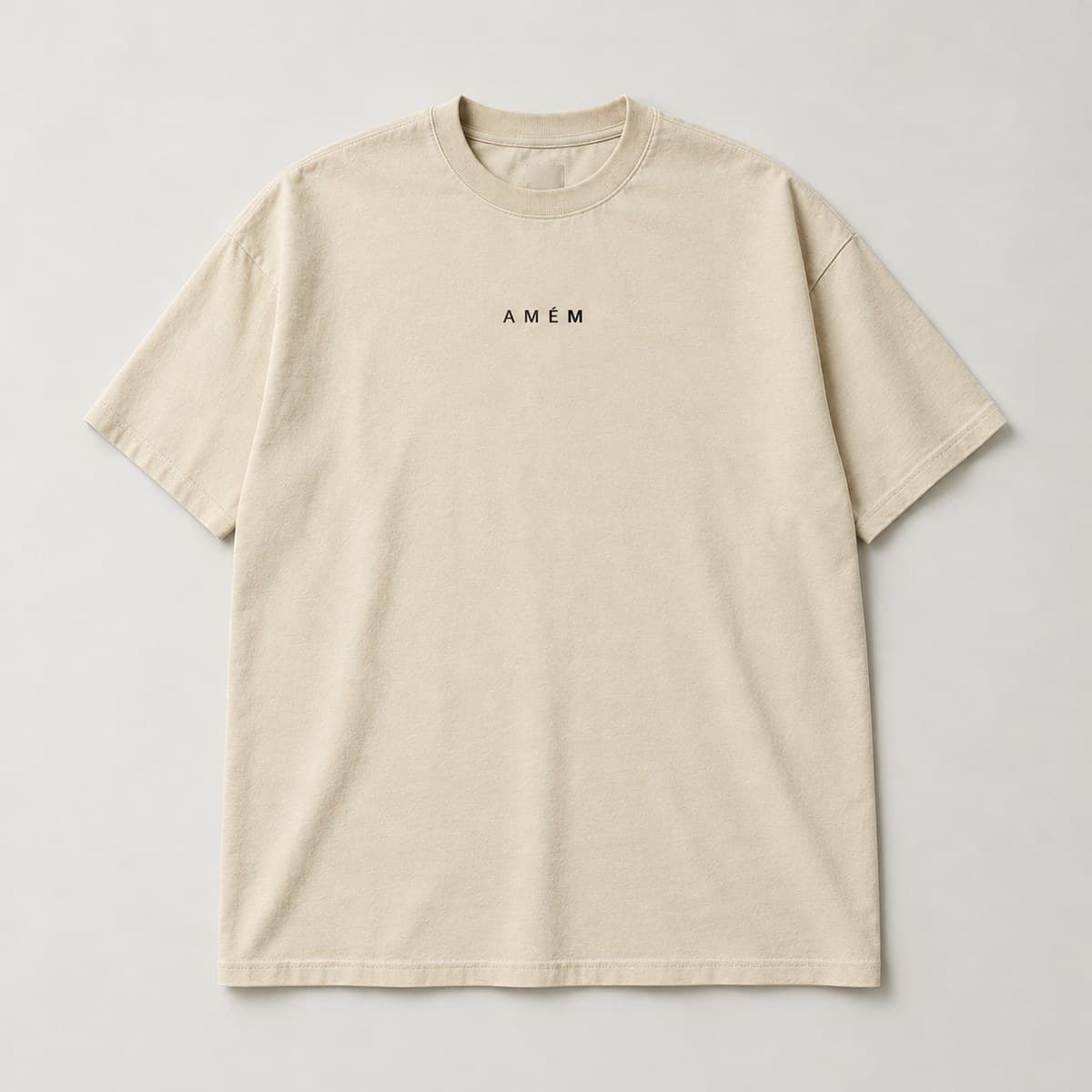 Camiseta “Amém”, modelo Oversized Premium, cor Bege, frente: "AMÉM." pequeno